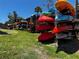 Outdoor kayak storage with colorful kayaks on metal shelving next to a grassy area and trees at 8977 Midnight Pass Rd # 521, Sarasota, FL 34242