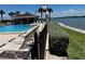 Community pool area featuring lounge chairs, a covered pavilion, lush landscaping, and waterfront views at 8977 Midnight Pass Rd # 521, Sarasota, FL 34242