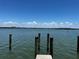 Scenic waterfront view with wooden pilings in the water under a bright blue sky at 8977 Midnight Pass Rd # 521, Sarasota, FL 34242