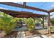 Backyard outdoor living area with bar, hot tub, dining table and fan under a beautiful wood pergola at 9089 Berendo Ave, Englewood, FL 34224