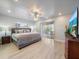 This bedroom features a ceiling fan, recessed lights, wood floors, a large bed, and sliding glass doors at 9089 Berendo Ave, Englewood, FL 34224