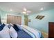 The light blue bedroom offers lots of pillows, a coastal decor, and a ceiling fan at 9089 Berendo Ave, Englewood, FL 34224