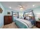 The turquoise bedroom offers lots of natural light with a large bed and coastal decor at 9089 Berendo Ave, Englewood, FL 34224