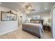 The primary bedroom boasts wood-look tile flooring, a ceiling fan, a decorative mirror, and access to an ensuite bathroom at 9089 Berendo Ave, Englewood, FL 34224