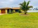 Charming yellow home with a well-manicured lawn and a decorative palm tree in the front yard at 9089 Berendo Ave, Englewood, FL 34224