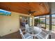 The screened-in patio features a wood ceiling with ceiling fan and an outdoor dining set at 9089 Berendo Ave, Englewood, FL 34224