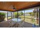 Relaxing screened porch with outdoor dining set and view of the backyard at 9089 Berendo Ave, Englewood, FL 34224