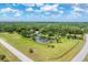 Expansive property with a pond and fountain, surrounded by lush greenery and a paved driveway at 919 Palm View Way, Sarasota, FL 34240