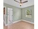 Light-filled bedroom with hardwood floors, ceiling fan, and a view of the outdoors at 919 Palm View Way, Sarasota, FL 34240