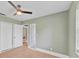 Bedroom with light-green walls, wood floors, ceiling fan, and a double door closet at 919 Palm View Way, Sarasota, FL 34240