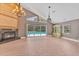 Open-concept living room with fireplace, large windows offering serene pool views at 919 Palm View Way, Sarasota, FL 34240