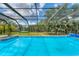 Refreshing screened-in pool with lush green surroundings, perfect for relaxation and outdoor enjoyment at 919 Palm View Way, Sarasota, FL 34240