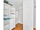Walk-in closet features custom shelving and a wooden floor at 919 Palm View Way, Sarasota, FL 34240