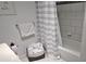 Bathroom featuring a shower/tub with a striped curtain, a towel rack, and a basket full of rolled white towels at 1016 Rhodes Ave, Sarasota, FL 34237