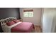 Bedroom with a modern accent wall, window with blinds, and a stylish white frame bed with a red quilt at 1016 Rhodes Ave, Sarasota, FL 34237