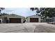 Single-story home features a long driveway to the garage, a trailer, and landscaping at 1016 Rhodes Ave, Sarasota, FL 34237