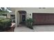 Home exterior featuring a garage, front door, manicured bushes, and stone walkway at 1016 Rhodes Ave, Sarasota, FL 34237
