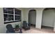 Porch featuring black chairs, an arched entrance, brick flooring, and a window at 1016 Rhodes Ave, Sarasota, FL 34237