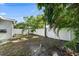 The backyard features a white privacy fence, palm trees, and ample space for outdoor activities and landscaping projects at 1019 S Tuttle Ave, Sarasota, FL 34237