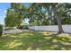 Well-maintained yard with mature trees, a white fence, and lush green lawn at 1019 S Tuttle Ave, Sarasota, FL 34237