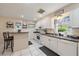 Bright kitchen featuring white cabinetry, tile flooring, and a breakfast bar for casual dining at 1019 S Tuttle Ave, Sarasota, FL 34237