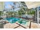 Sparkling screened-in pool and spa surrounded by lush landscaping creates a private oasis at 1019 S Tuttle Ave, Sarasota, FL 34237