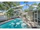 Relaxing screened-in pool area with lush trees creates a peaceful atmosphere at 1019 S Tuttle Ave, Sarasota, FL 34237