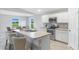 Kitchen boasts stainless appliances, white cabinetry, neutral countertops, and views of the dining area at 10539 Kidron Ave, Englewood, FL 34224