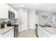 Clean kitchen with stainless appliances, white cabinets, and neutral countertops at 10539 Kidron Ave, Englewood, FL 34224