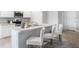 Bright kitchen with counter seating, stainless sink, white cabinets and neutral countertops at 10539 Kidron Ave, Englewood, FL 34224