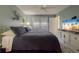 Bedroom featuring pale blue walls, white trim, and a view of palm trees on TV at 11021 4Th E Ave, Bradenton, FL 34212