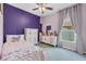 This bedroom has a purple accent wall, white dressers, and pink butterfly accents at 11208 Blue Sage Pl, Lakewood Ranch, FL 34202
