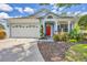 Charming single-Gathering home with a well-maintained lawn, an attached two-car garage, and a vibrant red front door at 11208 Blue Sage Pl, Lakewood Ranch, FL 34202