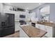Modern kitchen featuring white cabinets, stainless steel appliances, granite countertops, and a sleek island at 11208 Blue Sage Pl, Lakewood Ranch, FL 34202