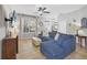 Cozy living room features a comfortable blue sofa, tile floors, a ceiling fan, and lots of natural light at 11208 Blue Sage Pl, Lakewood Ranch, FL 34202