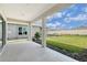 Covered back porch overlooking the green backyard with a view of the neighboring fences at 11427 Viani Ter, Palmetto, FL 34221