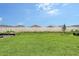Expansive backyard with lush green grass, bordered by a white fence and manicured landscaping, perfect for outdoor activities at 11427 Viani Ter, Palmetto, FL 34221