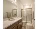 Bathroom with a white countertop, brown cabinets, single sink and sliding glass shower doors at 11427 Viani Ter, Palmetto, FL 34221
