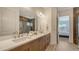 Modern bathroom with double sinks, white countertop, and a view of the tile shower at 11427 Viani Ter, Palmetto, FL 34221