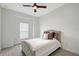 Cozy bedroom featuring a ceiling fan, large window, and comfortable bed at 11427 Viani Ter, Palmetto, FL 34221