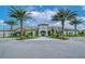 Elegant clubhouse exterior with symmetrical landscaping, palm trees, and a circular driveway for convenient access and curb appeal at 11427 Viani Ter, Palmetto, FL 34221