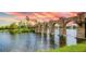 Scenic view of a lake with a beautiful stone bridge and fountain at sunset at 11427 Viani Ter, Palmetto, FL 34221
