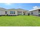 Exterior view of a modern home and a lush green lawn with landscaping and newly planted shrubs at 11427 Viani Ter, Palmetto, FL 34221