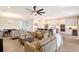 Open-concept living room with a large ceiling fan, recessed lighting, and access to the kitchen at 11427 Viani Ter, Palmetto, FL 34221