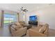 Bright living room featuring tile floors, a ceiling fan, and views of the backyard at 11427 Viani Ter, Palmetto, FL 34221