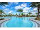 Community pool featuring sunshades, lounge seating, and lush landscaping at 11427 Viani Ter, Palmetto, FL 34221