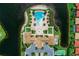 Overhead drone shot of community pool with ample deck, lounge seating, and manicured grounds at 121 Porta Vecchio Bnd # 201, Nokomis, FL 34275