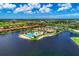 A beautiful aerial view showcasing the community pool, lake and lush landscapes on a sunny day at 121 Porta Vecchio Bnd # 201, Nokomis, FL 34275