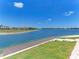 Scenic backyard with lake access, a wooden deck, manicured lawn, and gorgeous water views at 121 Porta Vecchio Bnd # 201, Nokomis, FL 34275