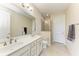 Bright bathroom featuring double vanity sinks, a walk-in shower, and neutral tile flooring at 121 Porta Vecchio Bnd # 201, Nokomis, FL 34275